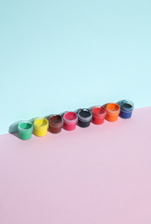 Set of gouache paint in jars on a pastel backgroundの写真素材