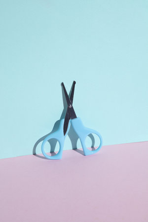Children's scissors in a blue-pink backgroundの写真素材