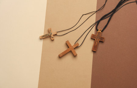 Wooden Christian crosses on a string, beige background. Top viewの写真素材