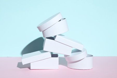 Pile of white gift boxes on pastel pink and blue background