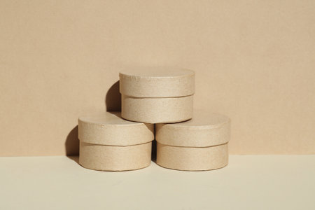 Round craft cardboard boxes for product on beige background