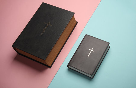 Holy Bible books on a pink blue background. Christian religion