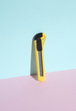 Paper knife on pastel color background