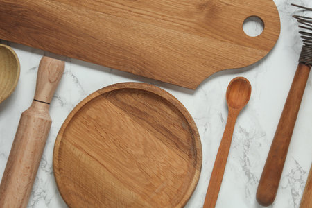Wooden kitchen utensils on a marble background. Top view. Flat lay