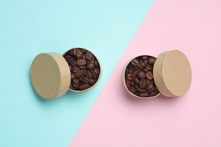 Coffee beans in boxes on a pink blue background. Top view