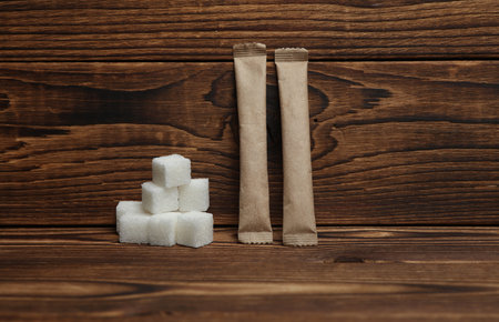 Disposable paper craft sticks with sugar cubes on a wooden backgroundの写真素材