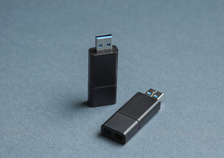 Two black USB flash drives on dark gray backgroundの写真素材