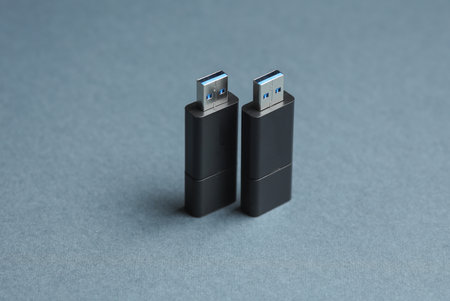Two black USB flash drives on dark gray backgroundの写真素材