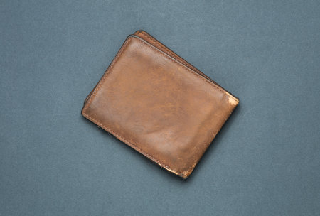 Old shabby leather wallet on a dark gray backgroundの写真素材