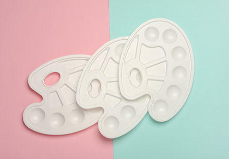 Empty paint pallets on a pink blue backgroundの写真素材