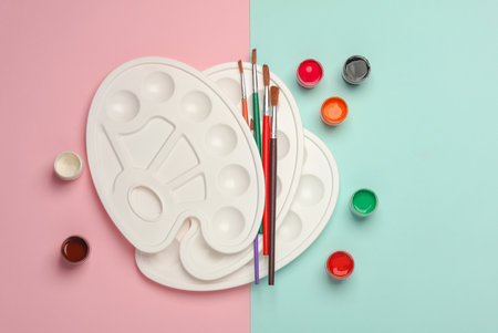 Paint pallet and jars of gouache, brushes on a pastel background. Top viewの写真素材