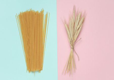 Pasta and spikelets of wheat on a blue-pink backgroundの写真素材