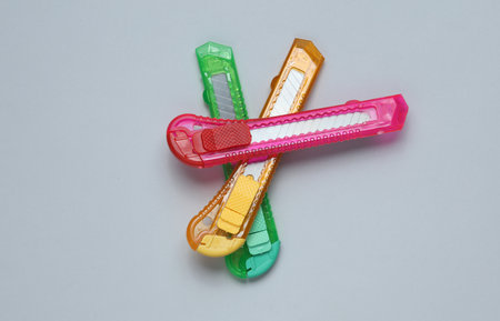 Plastic colored stationery knives for cutting paper on a gray backgroundの写真素材