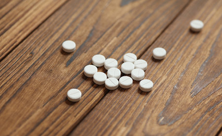 White pills on a wooden background. Medicine concept