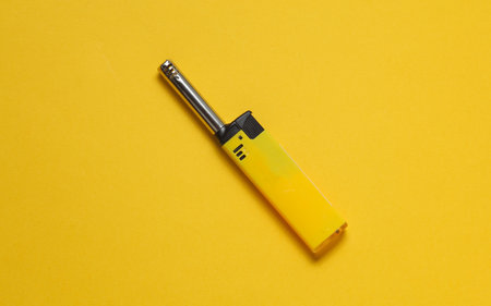 Household lighter on a yellow background. Top viewの写真素材