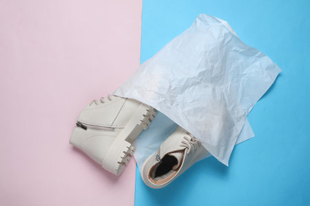 Women's new white leather winter boots with pack on a blue-pink background. Top viewの写真素材
