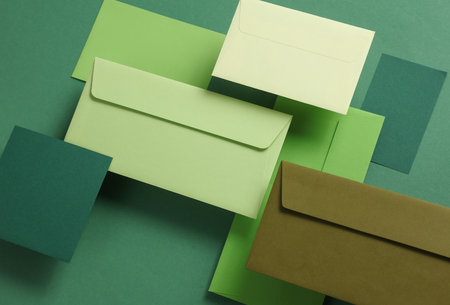 Set of floating green tones envelopes and cards on green background. Invitations, corporate...