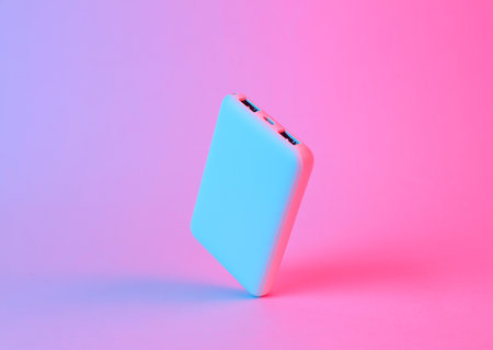 Floating power bank in blue-pink gradient neon lightの写真素材