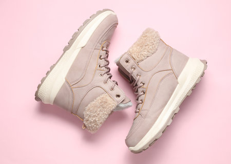 Women's winter boots on a pink background. Top view
