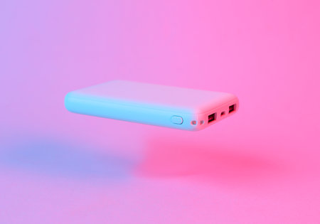 Floating power bank in blue-pink gradient neon lightの写真素材