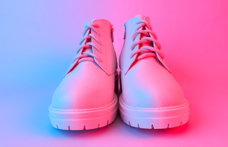 White leather boots in blue-red gradient neon light. Creative fashion still lifeの写真素材