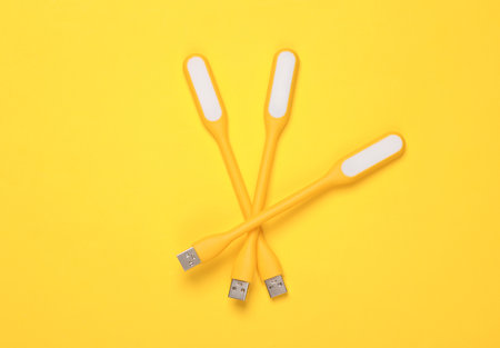 Flexible yellow USB lamps on yellow background. Top viewの写真素材