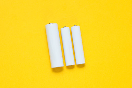 White blank aa and aaa batteries or accumulators on a yellow background. Mockup for designの写真素材