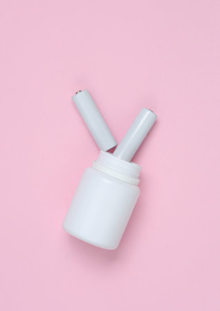 Pills bottle with AA batteries on a pink background