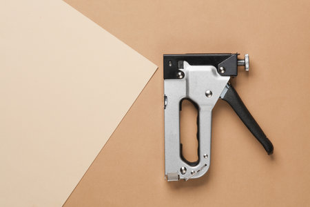 Construction stapler on beige brown backgroundの写真素材
