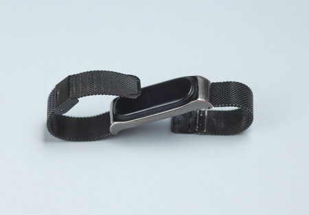 Modern smart bracelet on gray background.