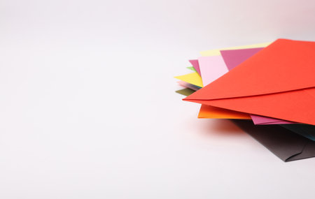 Stack of colored envelopes on white backgroundの写真素材