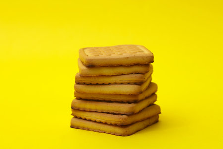 Stack of delicious cookies on yellow backgroundの写真素材