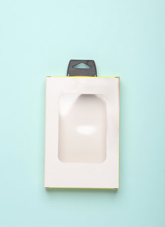 Cardboard packaging box with a transparent window on a blue background