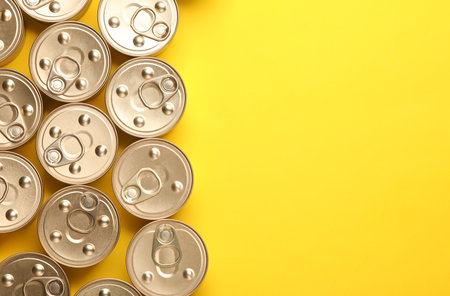 Cans with canned pet food on yellow background. Top view. Flat lay. Copy spaceの写真素材