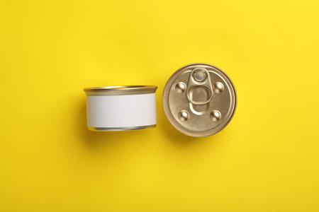 Cans with canned pet food on yellow background. Top view. Flat lay. Mockup for designの写真素材