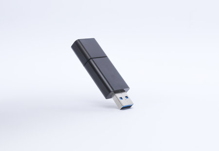 Black plastic flash drive floating on a white background