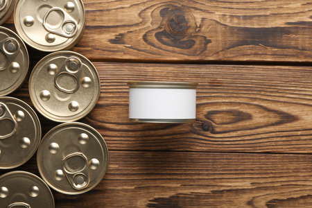 Many Cans with canned food on wooden background. Top view. Mockup for design