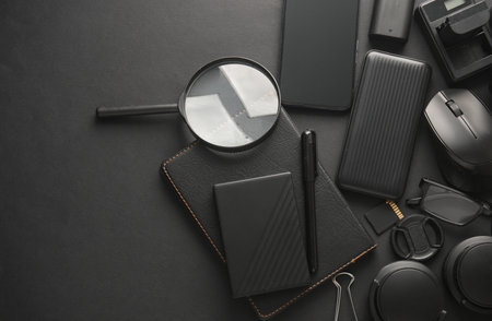 Flat lay composition of Modern black gadgets and accessories on dark black background. Top view.