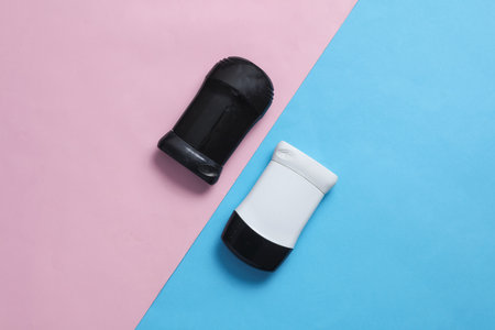 Black and white antiperspirant tubes on blue pink background. Sweat protection. Top viewの写真素材
