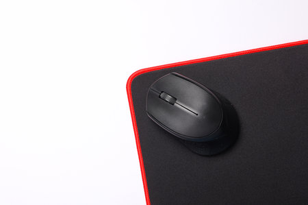 Black PC mouse with PC mouse pad on a black background