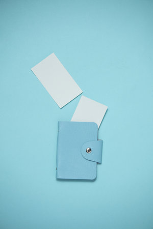 Blue leather business card holder with white blank business cards on a blue background. Top viewの写真素材