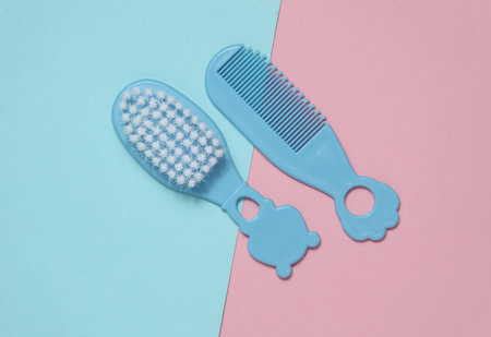 Combs and hairbrush for newborn on a blue-pink backgroundの写真素材