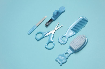 Baby care set on a blue background. Scissors, comb, nail file and tweezers. Top viewの写真素材