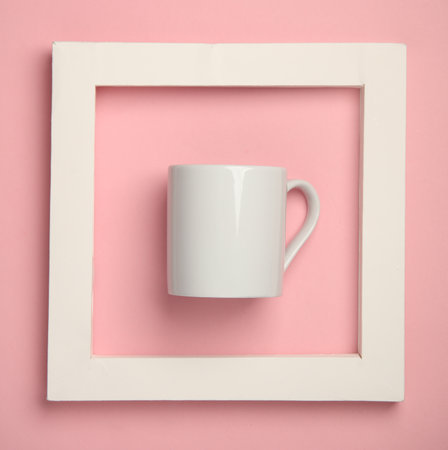 White ceramic cup in a square frame on a pink backgroundの写真素材
