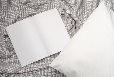 White blank magazine mockup on a blanket with pillowの写真素材