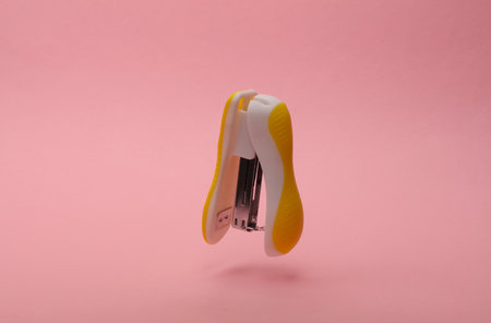 Stapler floating on a pink backgroundの写真素材