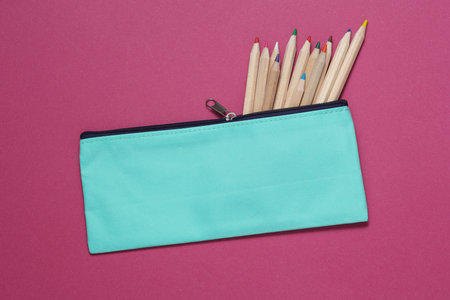 School pencil case with colored pencils on a pink background. Back to school concept