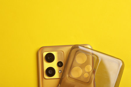 Smartphone with silicone protective case on a yellow backgroundの写真素材