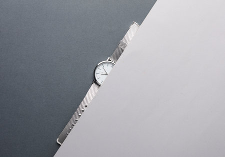 Women's wrist analog watch with metal or silver strap on gray background. Flat lay. Top viewの写真素材