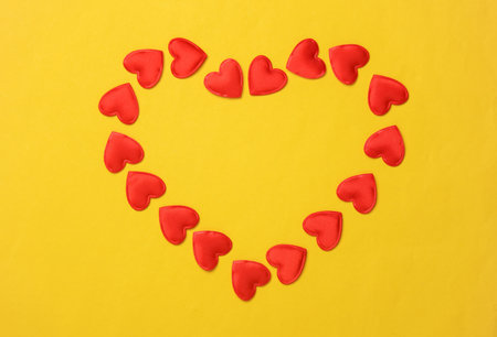 Red heart shaped hearts on a yellow background. Valentine's day backgroundの写真素材